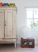 Ethnic trunk and lantern next to white cupboard