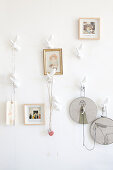 Pictures and embroidering frames hung from stylised twig-shaped hooks