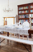 Rustic wooden table set in white in front of bookcase
