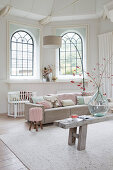 Living room in pale shades with arched windows and high ceiling