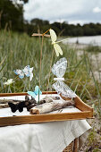 Handmade butterflies and dragonflies on driftwood in a tray