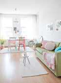 Light-flooded living room with sofa and dining area