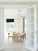 looking through the open glass door into the bright, Scandinavian-style dining room