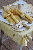 Candles rolled from beeswax sheets, beekeeping books and paper tags