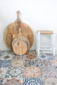 Wooden cutting boards and stools on a Moroccan tiled floor