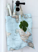 Fabric bag with a world map motif and rolled up maps