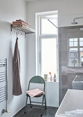 Folding chair and cloakroom in a bathroom with a window