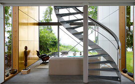 A curved staircase in the living room of a modern architectural house