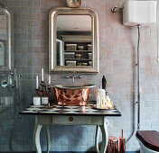 Metall-Waschbecken auf Holztisch unter antiker Spiegel im Badezimmer