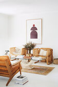 Leather armchairs and rattan armchairs around coffee table with glass top