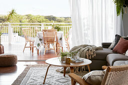 Blick vom Wohnzimmer mit Polstersofa und Coffeetable auf die Terrasse