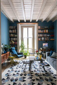 Teppich mit geometrischem Muster im Wohnzimmer mit blauen Wänden und Retro Einrichtung