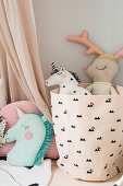Soft toys in pink fabric storage basket