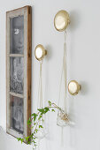 Ivy in macramé plant hangers hung from round golden pegs