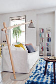 Modernes Wohnzimmer mit Sofa, schwenkbarer Stehlampe und blau-weißem Teppich