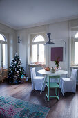 Loose-covered chairs at dining table in festively decorated interior