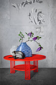 White glass vase, blue ceramic vase with fish pattern and china monkey on red steel mesh table