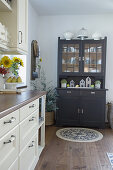 Off-white kitchen counter and grey dresser in country-house style in kitchen-dining room