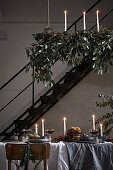 Festively set, candlelit dining table in loft-apartment interior