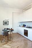 Dining table in small kitchen-dining room with kitchen counter and herringbone parquet floor