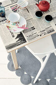 Dining table decoratively covered with newsprint decoupage