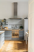 Pale grey fitted kitchen with island counter