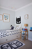 Batman-Motiv über Kinderbett mit schwarz-weißer Stern-Bettwäsche