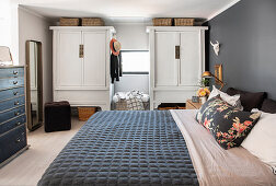 Bed and wardrobes in sleeping area on gallery of penthouse apartment