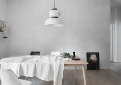 White tablecloth, carafe and eucalyptus branch on pale wooden table