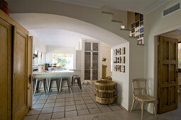White country-house kitchen with tiled floor and stools at breakfast bar