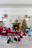 Weihnachtsbaum und Möbel in Blau und Rot vorm offenen Kamin