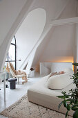 Modern sofa in attic living room with arched window