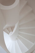 White spiral staircase with masonry balustrade