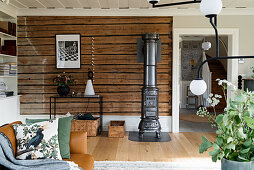 Rustic wooden wall and cast iron stove in classic living room