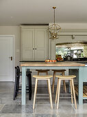 Various stools at breakfast bar in country-house kitchen