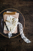 Bundle of letters tied with lace ribbon on glass plate with gilt edge