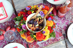 Colourful potato salad in wreath of flowers on set table