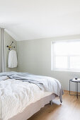 Doppelbett im Schlafzimmer mit hellen Wänden