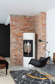 Cylindrical wood-burning stove against brick wall in living room