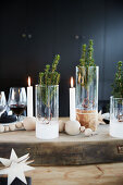 Candles, glass and wooden baubles on festively set wooden table