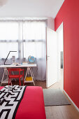 Bett und Schreibtisch in Jugendzimmer mit roten Farbakzenten