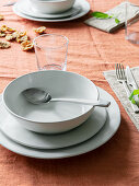 Table set with orange tablecloth and white crockery