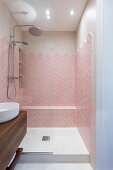 Pink herringbone tiles in small bathroom with shower
