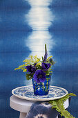 Anemone, goldenrod, veronica and sea holly in front of blue ikat pattern