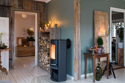 Log burner and stacked firewood in hallway