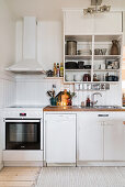 Cooker below extractor hood in charming white kitchen