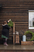 Frau hängt Weihnachtsdeko an Holzwand