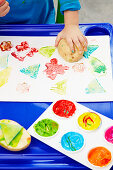 Child making colourful potato prints