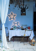 Gedeckter Tisch auf überdachter weihnachtlich dekorierter Terrasse