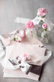 Pastel arrangement: envelopes tied with satin ribbons and pink carnations